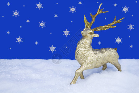 黄金假黄金驯鹿圣诞圣山大礼仪 站在雪雪的假雪上蓝色雪片传统背景季节性季节庆典假雪摄影装饰品背景