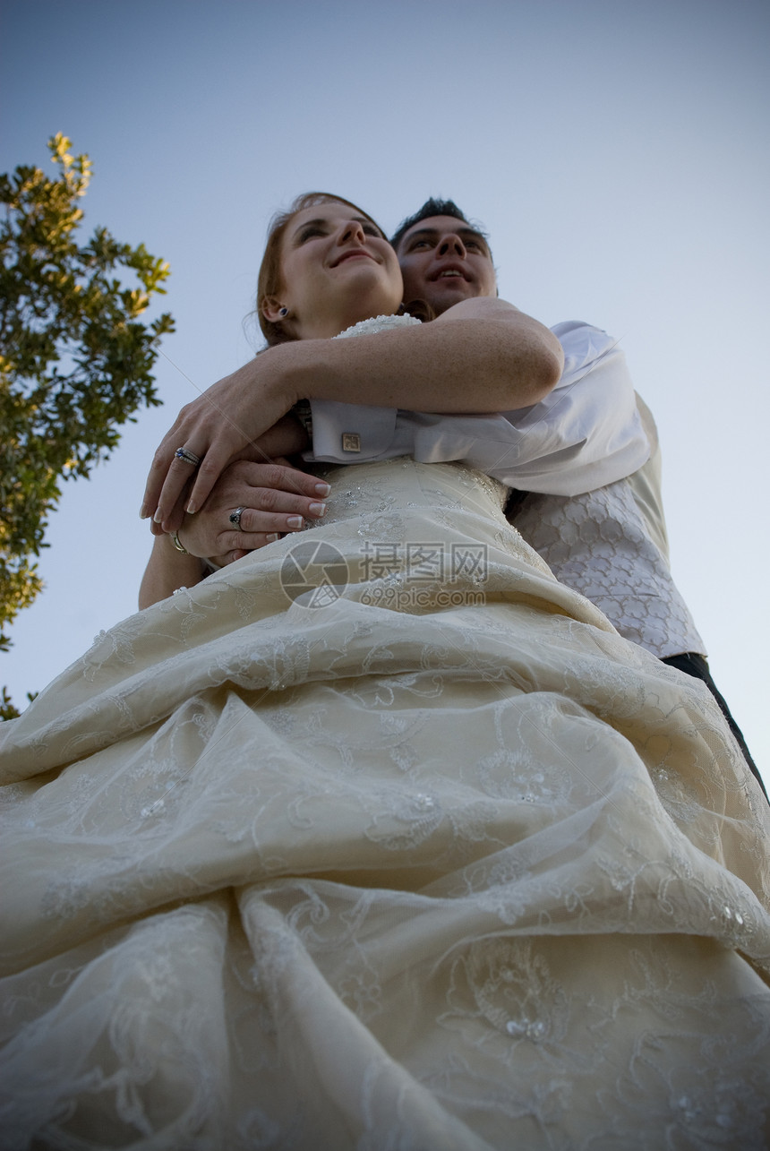 新新娘和新郎拥抱 站在蓝天的外面图片