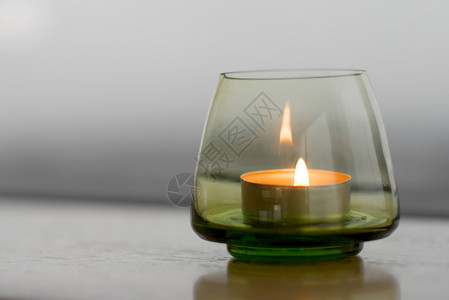 蜡烛持有者情绪玻璃灯芯燃烧风格装饰烛台绿色木头背景图片