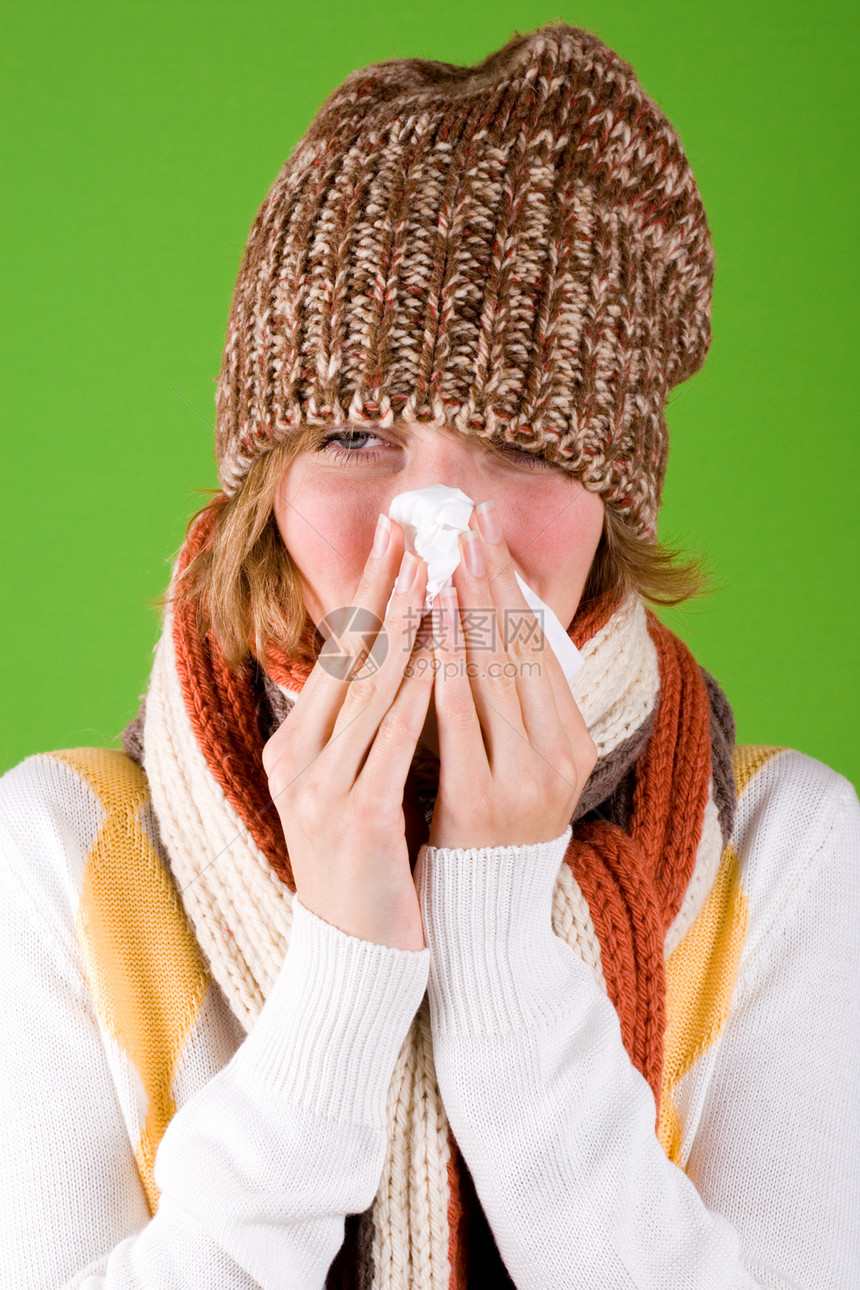 用手帕打喷嚏的女人针织帽子棕色流行病女士围巾感染绿色喷嚏流感图片