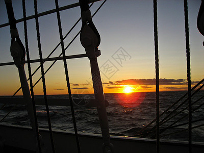 海上日落晴天水手启航蓝色游艇红色装备黄色帆船水手们背景图片