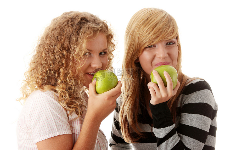 两个吃绿苹果的十几女友女性女孩青年乐趣女孩们微笑亲戚们快乐友谊学校图片