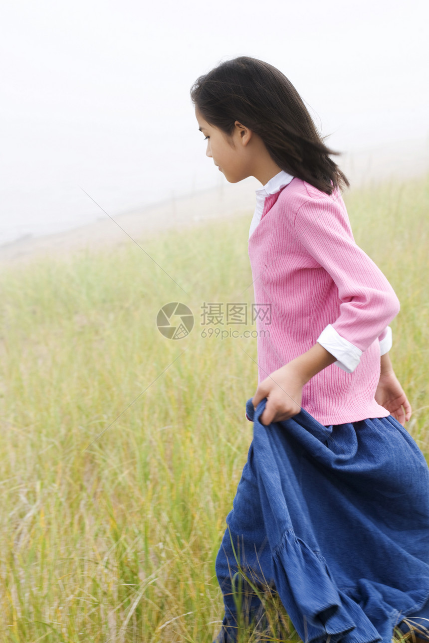 女孩跑下山坡爬坡跑步微笑享受乐趣精力场地空气绿色牧场图片