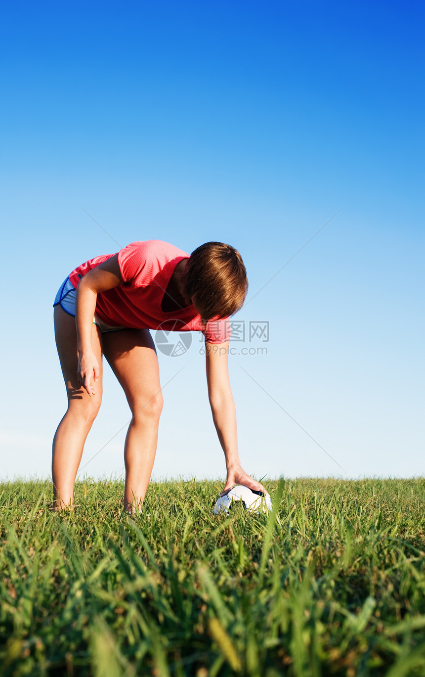 女青年足球运动员闲暇玩家乐趣娱乐天空力量蓝色游戏行动公园图片