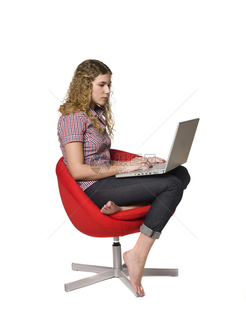 带着电脑坐在扶椅上的女孩笔记本科学网络工作工作室椅子扶手椅学习女士红色图片