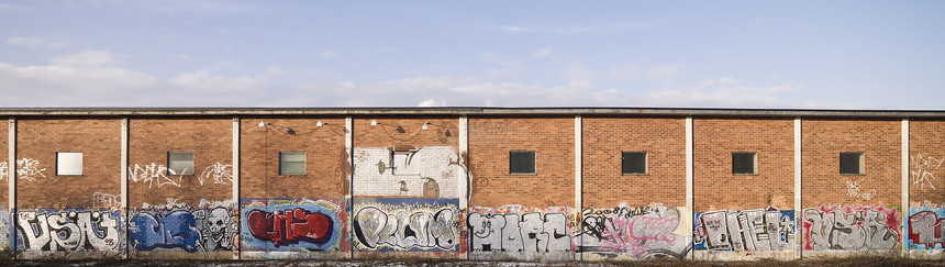 挂着涂鸦的砖墙工业房子全景平铺处所建筑学天堂大厅天空土坯图片