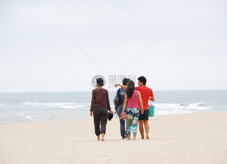 美丽的家庭在海滩上散步图片