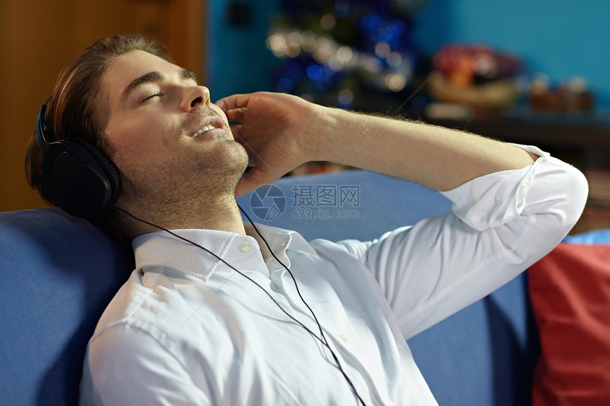 男用耳机听音乐的人长椅微笑男性音乐闲暇沙发衬衫白色眼睛娱乐图片