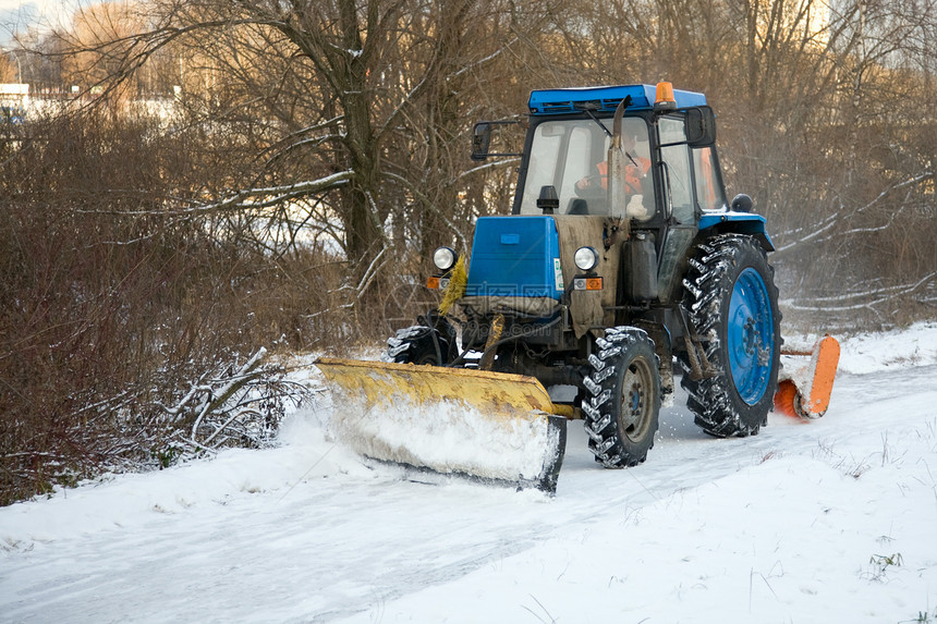 拖拉机在雪上铺路行驶图片