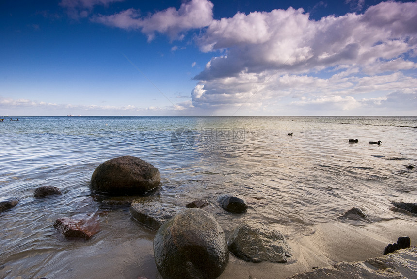 波罗的海和动态天空沉思场景海岸线石头反射岩石波形海滩假期阳光图片