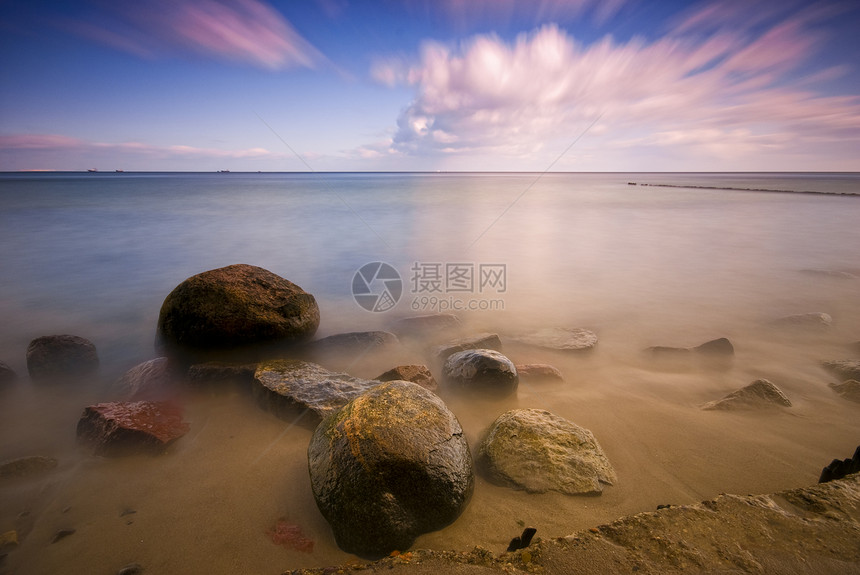 波罗的海和动态天空水面场景石头波形海岸线岩石沉思日落阳光假期图片