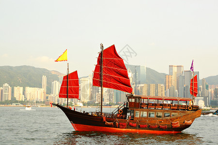有红帆船的香港港港旅游桅杆旗帜顶峰建筑血管爬坡蓝色旅行观光背景