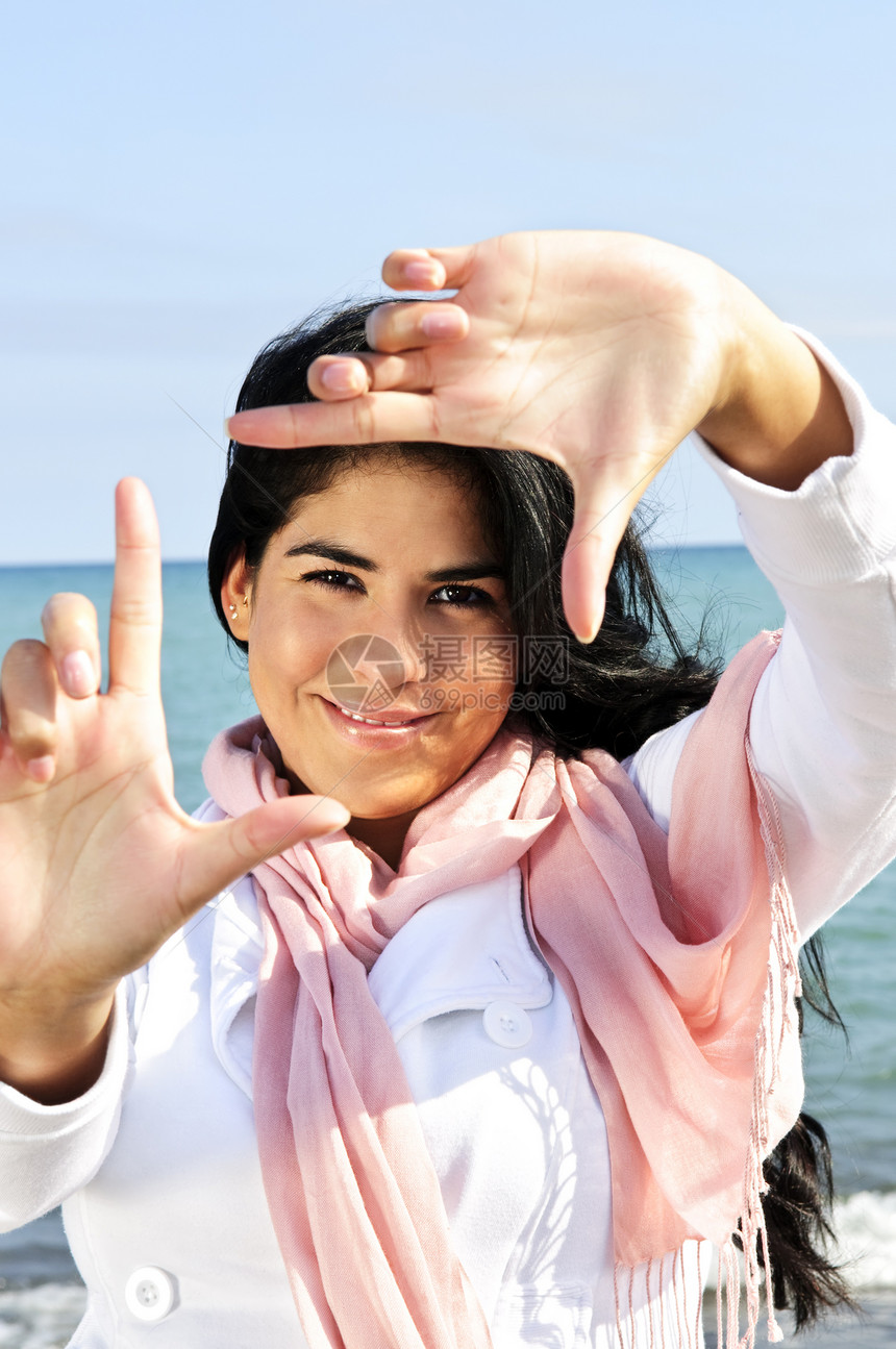 美丽的年轻女性 塑造自己的面容手指手势女孩幸福土著海滩假期快乐框架海洋图片