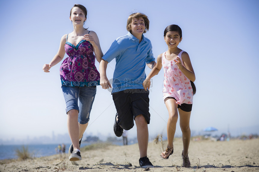 三个孩子跑在海滩上乐趣青少年幸福家庭海洋黑发男性女孩朋友们少年图片