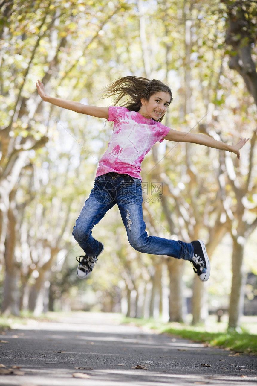 少女跳跃矫正享受女性跑步公园个性孩子牛仔裤牙齿青年图片