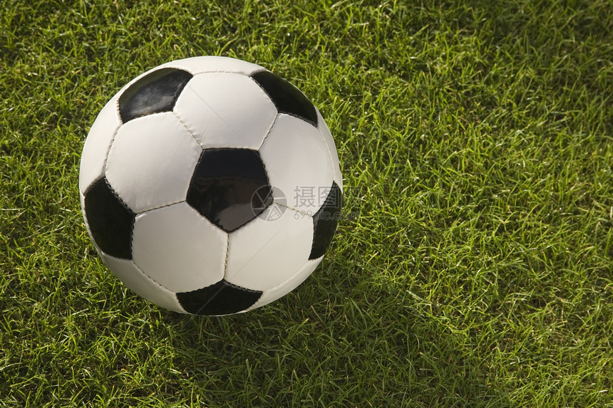 在草地上贴近黑白皮鞋足球体育摄影圆形绿色水平黑与白器材皮革图片