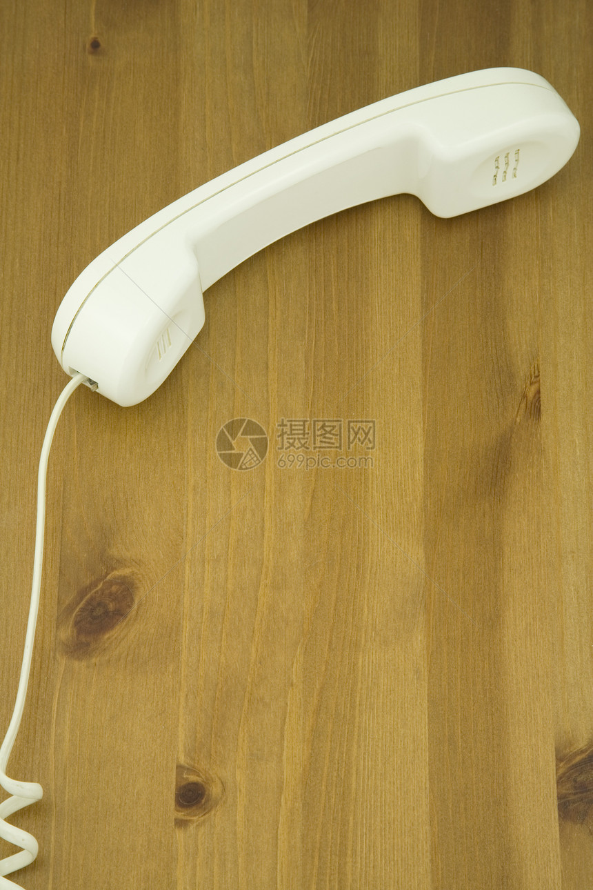 白色电话接收器在木制桌子上的高端视图图片
