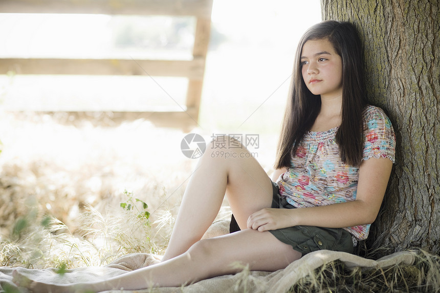 年轻女孩坐在树下寂寞孩子女性沉思孤独闲暇青年黑发童年悲伤图片
