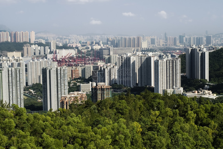 拥有绿色山丘和蓝天空的高高公寓城市地标建造天际摩天大楼住宅社区建筑学财产旅游图片