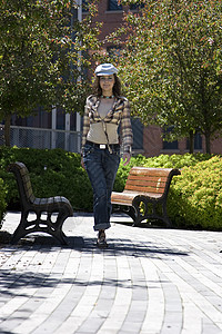 在公园里散步绿色长椅黑发青少年女孩树木帽子害虫孤独女士背景图片