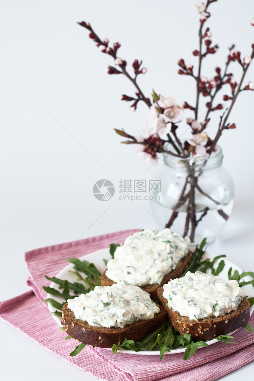 黑麦面包上吃奶酪零食 香菜和盛开的樱桃枝花束分支机构草药花朵玻璃绿色白色花瓶粉色组织面包图片