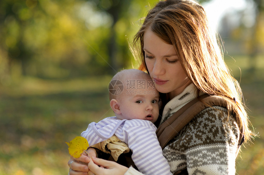 年轻母亲与婴儿在载体中头发妈妈草地童年压痛父母生活女士女孩女性图片