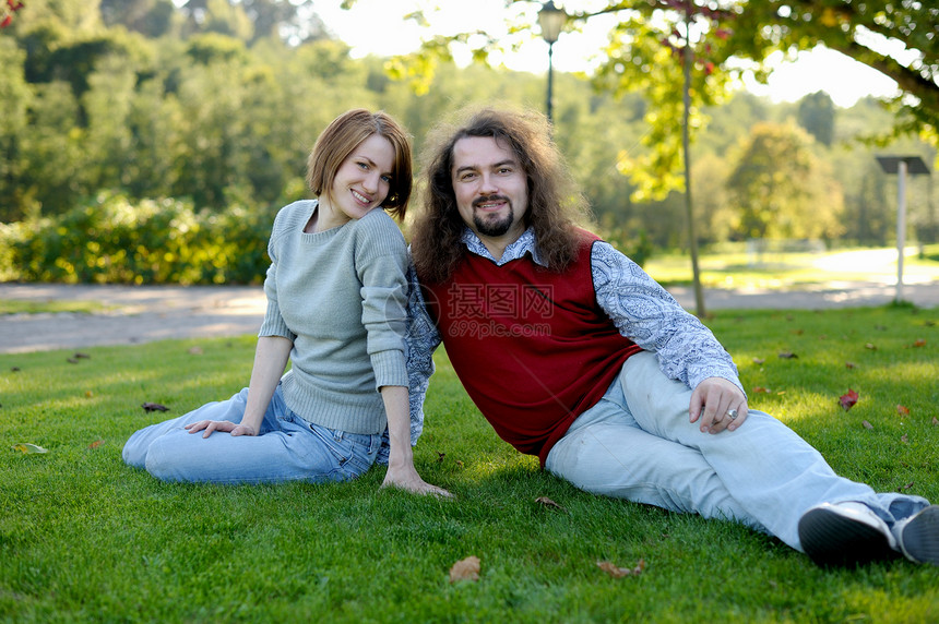 年轻夫妇坐在公园的草地上女朋友乐趣夫妻生活丈夫男人男性女性拥抱家庭图片