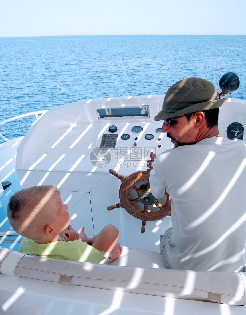 船上的小男孩和船长土地旅行太阳自由游艇快乐发动机航行阳光海浪图片