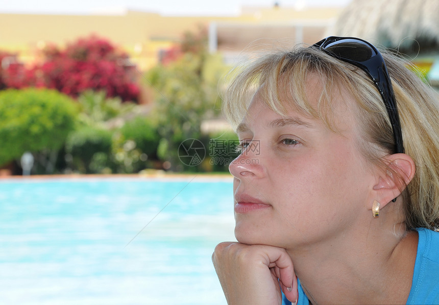 在度假村游泳池旁的年轻女子女孩假期酒店金发女性皮肤金发女郎水池蓝色头发图片