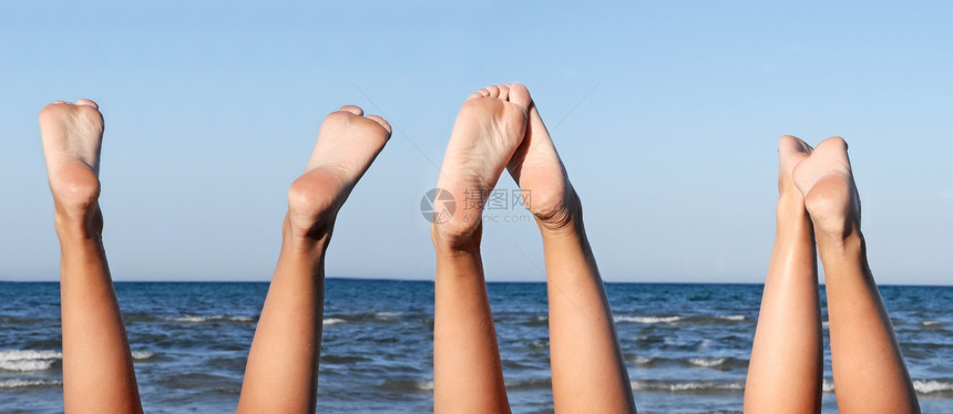 海滩上可爱的腿闲暇乐趣太阳假期蓝色女性天空海浪女孩们棕褐色图片