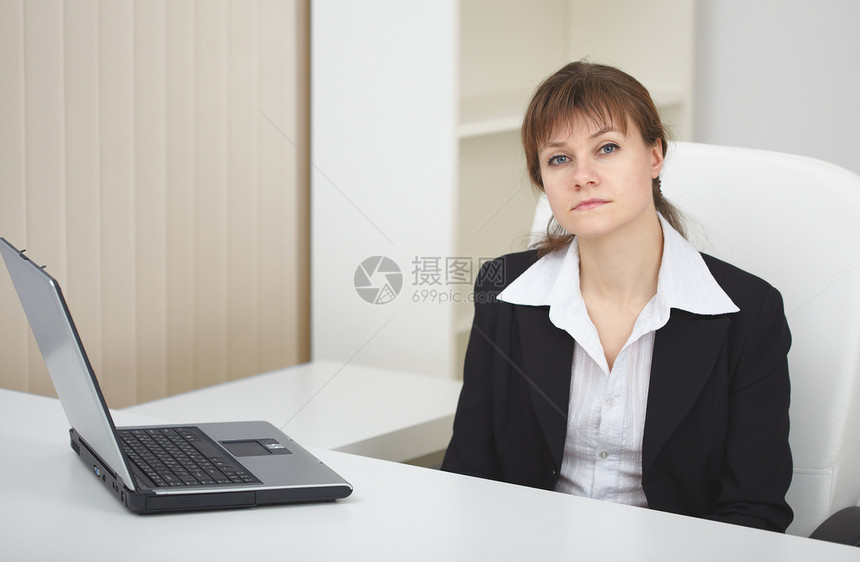 重度妇女用笔记本电脑坐在轻办公室的桌子上老板职场首席椅子秘书戏服经理人士扶手商务图片