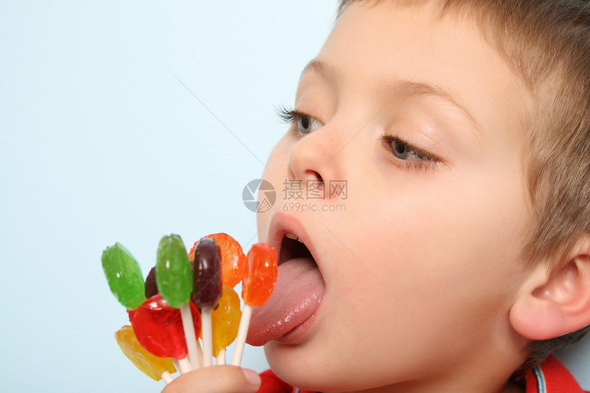 棒棒糖男孩食物微笑男生童年孩子乐趣蓝色桌子甜点青年图片