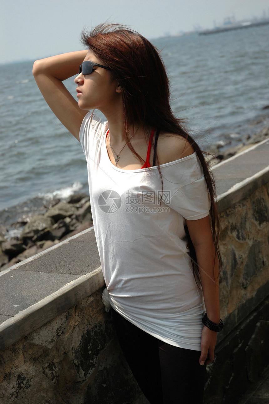 戴墨镜的年轻女士岩石身体太阳镜青年黑色数字娱乐女孩衬衫海滩图片