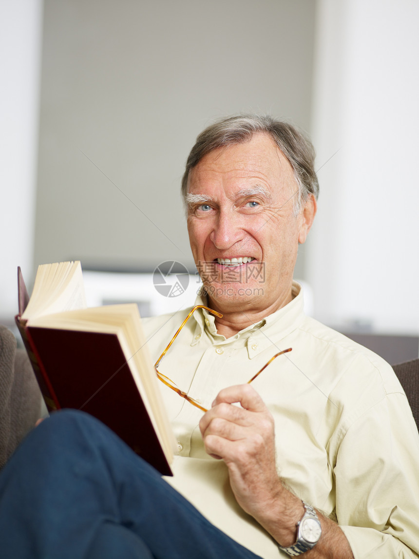 高级男子阅读书休闲人员老人沙发阅读退休白色爱好闲暇家庭图片