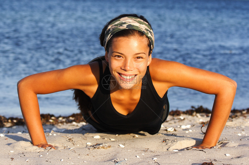 妇女做俯卧撑运动员女性身体有氧运动肌肉海滩公园训练黑发女士图片