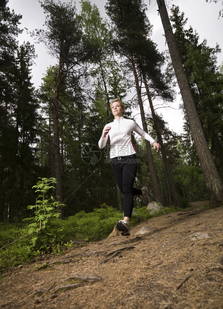 女人在树林里奔跑保健魅力天空场地木头医疗腹肌肌肉有氧运动锻炼图片