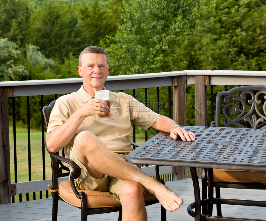 高年男子在花园喝啤酒丈夫晴天退休饮料院子桌子甲板快乐男人露台图片