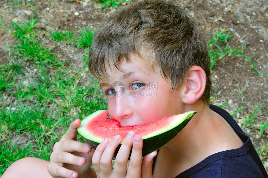 一个男孩 与一块西瓜图片