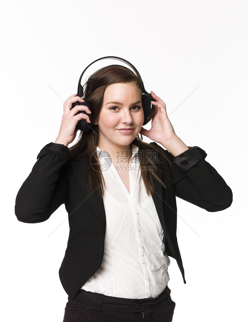 微笑的女孩听音乐音乐享受音乐播放器专注头发女性女士工作室耳机棕色图片