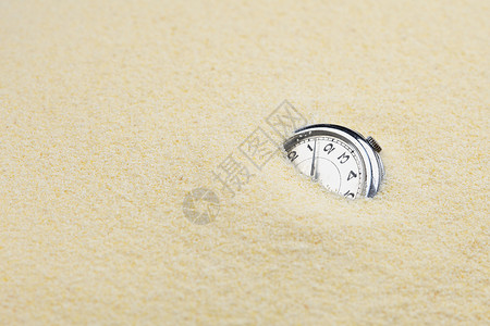 沙沙中的古老机械手表背景图片