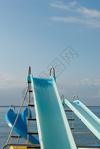 准备去海滩游乐闲暇蓝色海滨乐趣操场梯子溜槽乐园阳光晴天背景图片