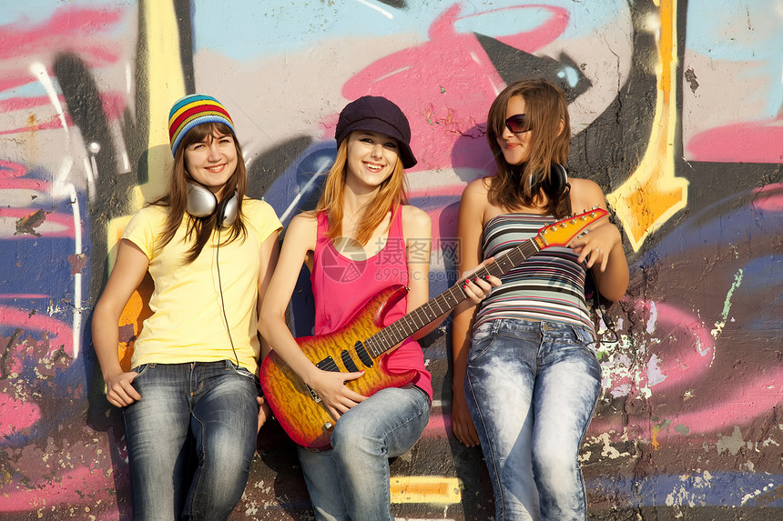 三个美丽的女孩 带着吉他和涂鸦墙 在背角乐趣音乐闺蜜岩石朋友们街道城市女士女性幸福图片