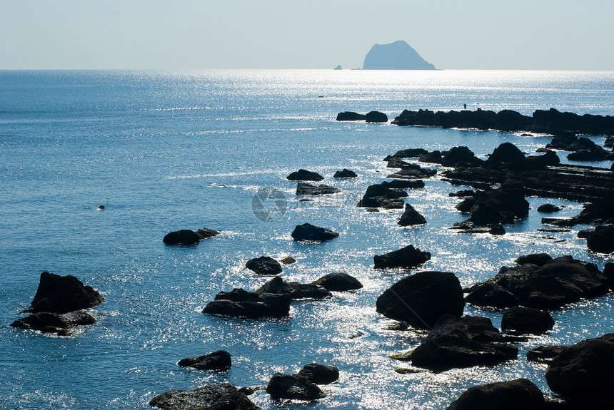岩海滨 阳光照耀的太阳光反射环境海景场景假期旅行海洋晴天海岸紫色蓝色图片