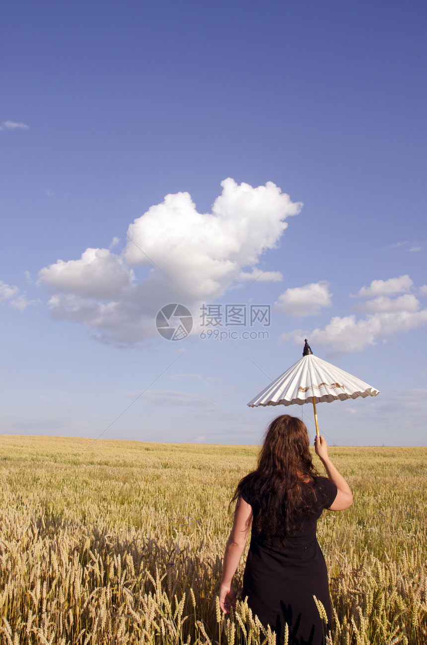 年轻妇女在小麦田中行走图片