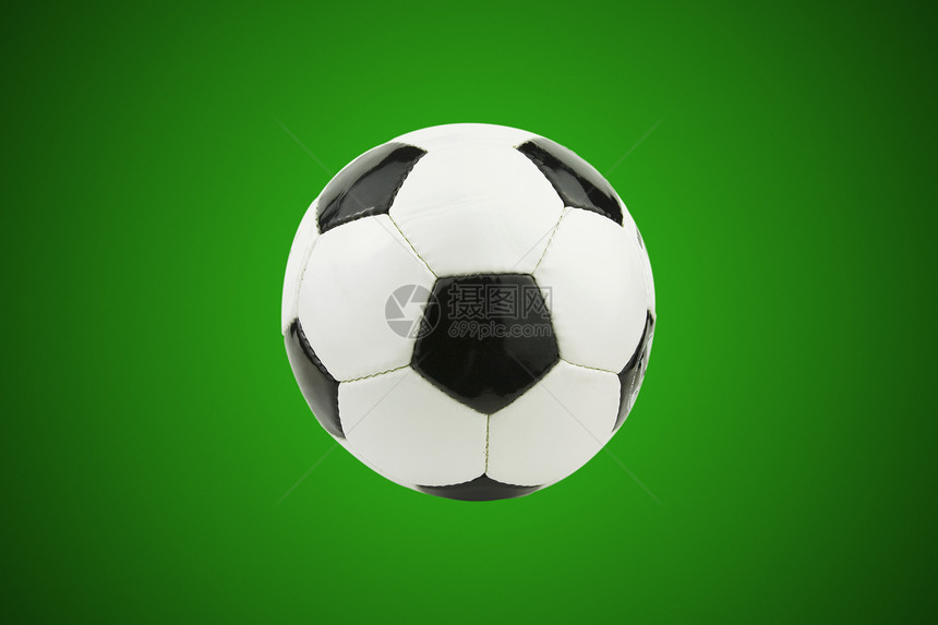绿色背景的黑色和白色皮革足球图片