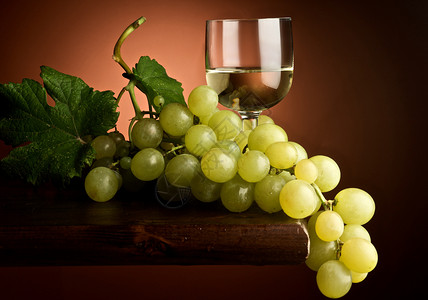 葡萄酒杯玻璃白酒葡萄园藤蔓树叶背景图片