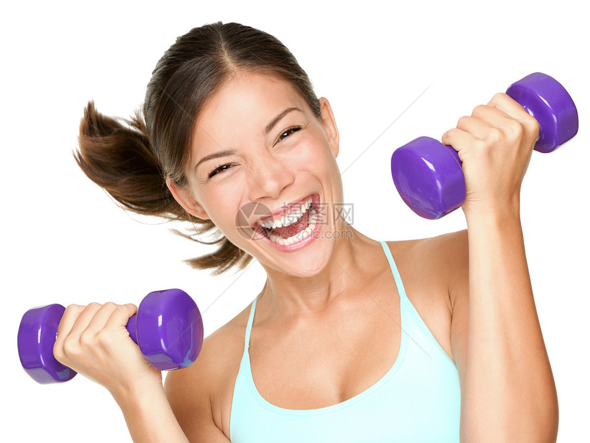 快乐的健身女举起哑铃幸福运动员女孩重量训练蓝色卷发女性肌肉健身房图片