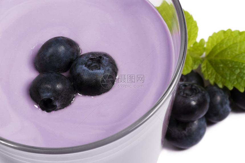 在蓝莓奶昔上方的蓝莓 加上蓝色浆果玻璃牛奶甜点奶油酸奶饮料活力叶子茶点果味图片