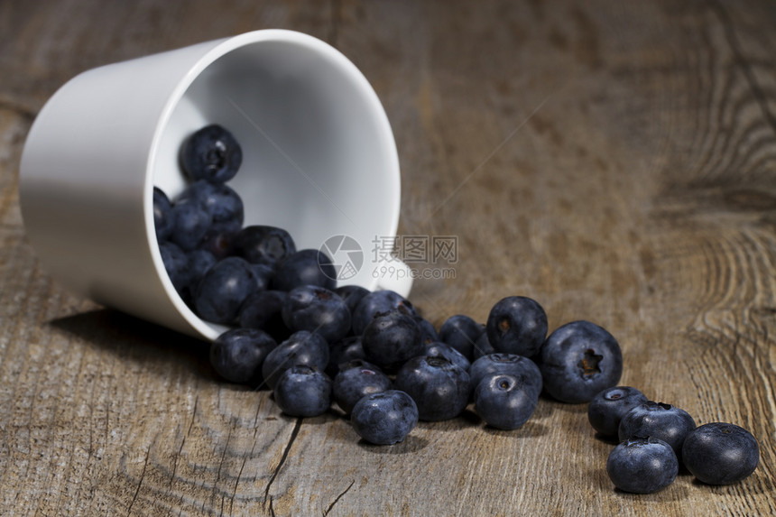 蓝莓从杯子上倒下滚动季节性水果食物浆果小吃甜点白色季节厨房饮食图片