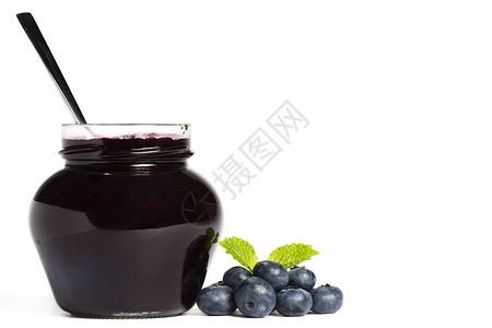 果酱罐加蓝莓果酱汤匙和蓝莓果及叶子梅莉萨背景图片